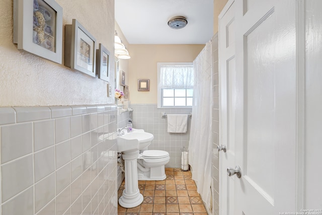 bathroom with tile walls, toilet, and tile patterned floors