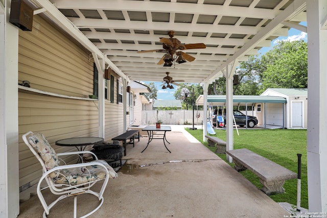 view of patio / terrace with ceiling fan and an outbuilding