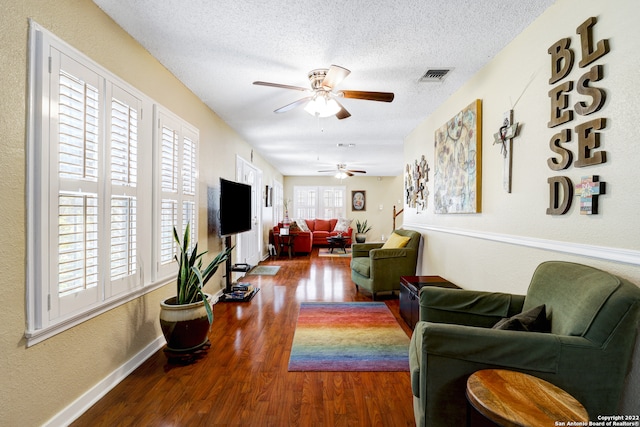 living room featuring a textured ceiling, hardwood / wood-style floors, and ceiling fan