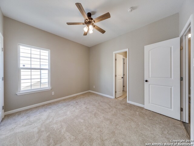 unfurnished bedroom featuring light carpet and ceiling fan