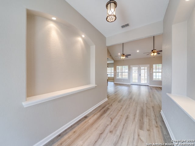 corridor featuring light hardwood / wood-style flooring and vaulted ceiling