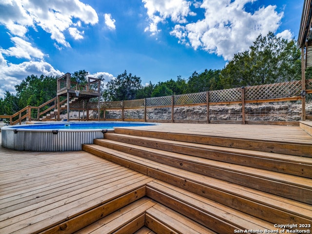 wooden deck featuring a fenced in pool