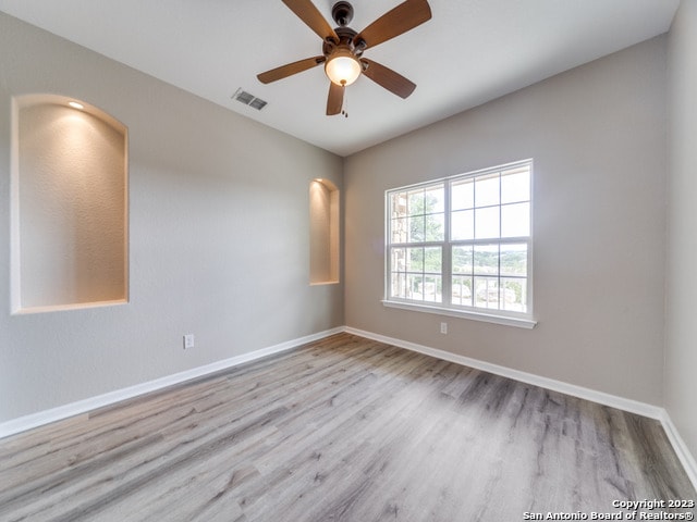 empty room featuring ceiling fan and light hardwood / wood-style flooring