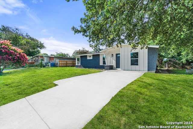 single story home featuring a front lawn and central AC unit