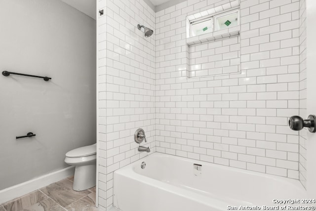 bathroom with tiled shower / bath and toilet