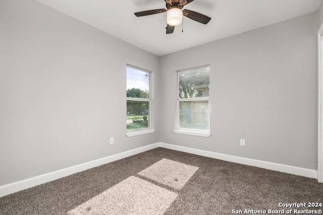 unfurnished room featuring ceiling fan and dark carpet