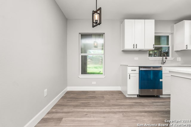 kitchen featuring light wood-type flooring, white cabinetry, decorative light fixtures, and stainless steel dishwasher