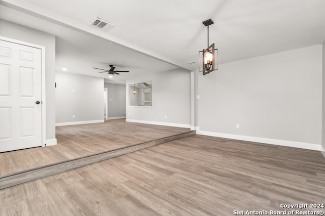 unfurnished living room featuring ceiling fan and wood-type flooring