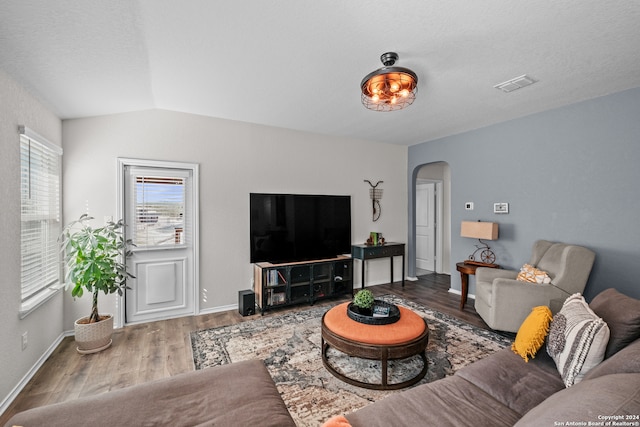 living room featuring a textured ceiling, lofted ceiling, and hardwood / wood-style floors