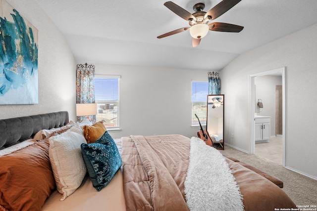 carpeted bedroom featuring lofted ceiling, ensuite bath, and ceiling fan