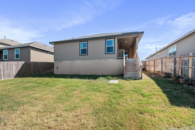 rear view of property featuring a lawn