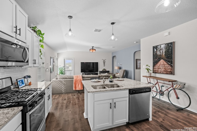 kitchen featuring white cabinets, stainless steel appliances, lofted ceiling, and decorative light fixtures