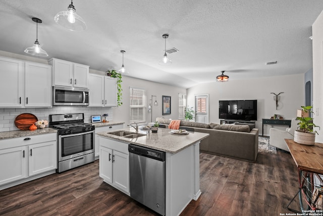 kitchen featuring appliances with stainless steel finishes, white cabinets, decorative light fixtures, dark hardwood / wood-style floors, and sink