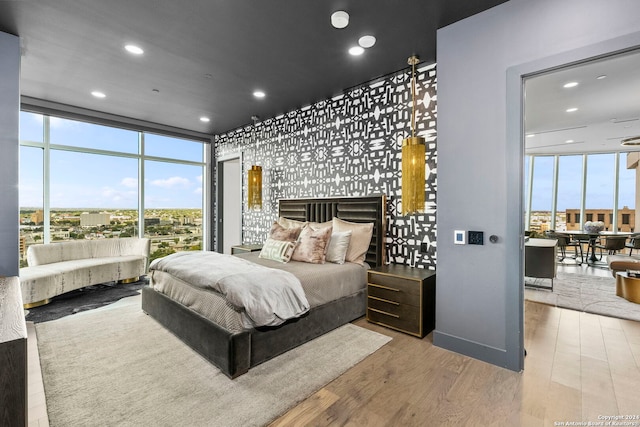 bedroom featuring expansive windows and hardwood / wood-style flooring