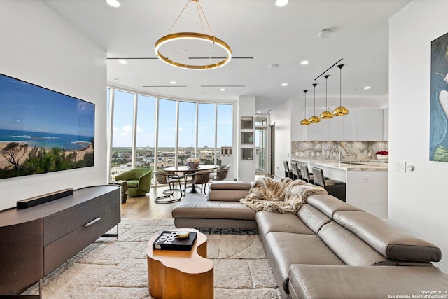 living room with expansive windows and light hardwood / wood-style flooring