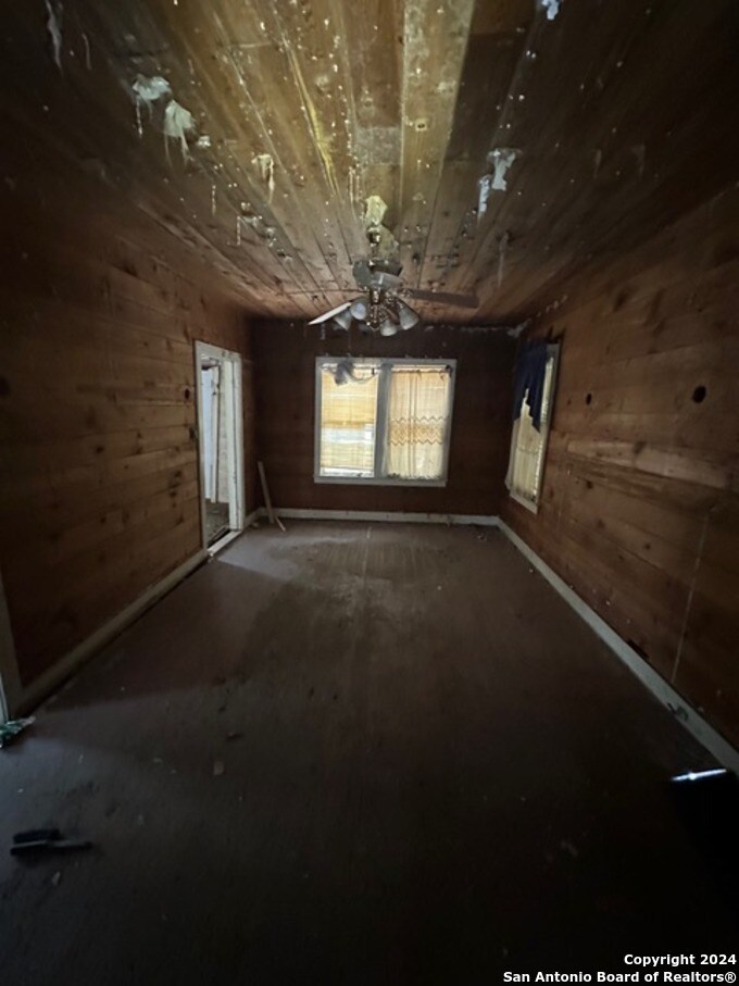 335 Elmhurst Ave, San Antonio, TX 78209 - spare room featuring wood ceiling and wooden walls