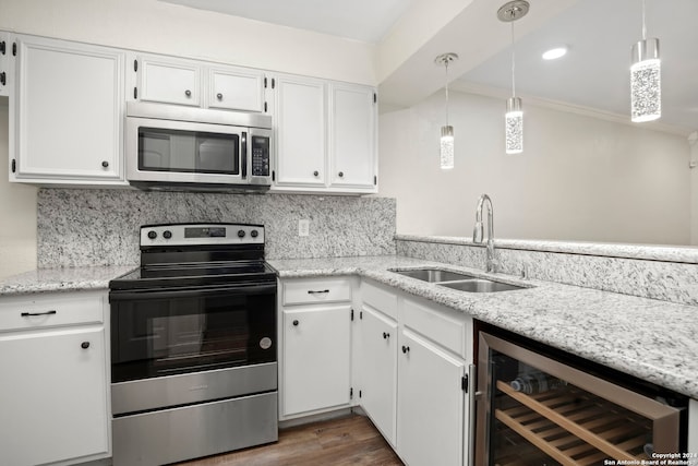 kitchen with sink, white cabinets, beverage cooler, stainless steel appliances, and decorative light fixtures