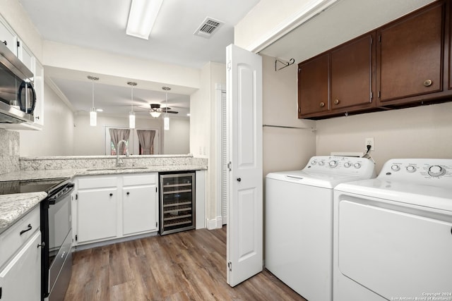 laundry area with independent washer and dryer, beverage cooler, light hardwood / wood-style flooring, ceiling fan, and sink