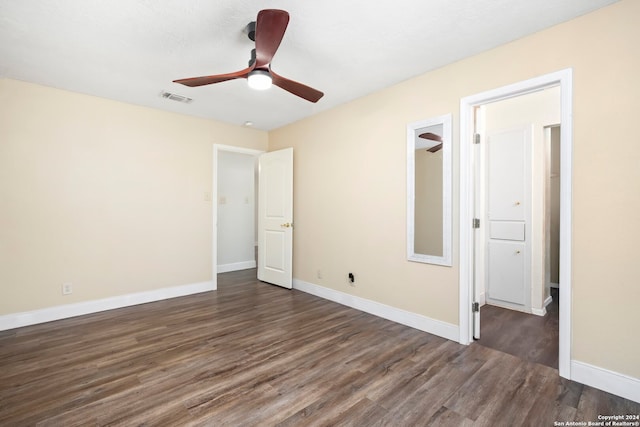 unfurnished bedroom featuring ceiling fan and dark wood-type flooring