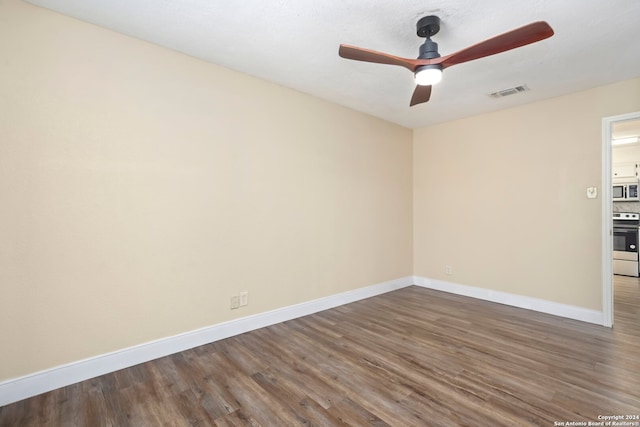 unfurnished room with ceiling fan and dark hardwood / wood-style floors