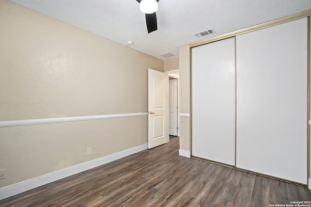 unfurnished bedroom featuring a closet, ceiling fan, and dark hardwood / wood-style flooring