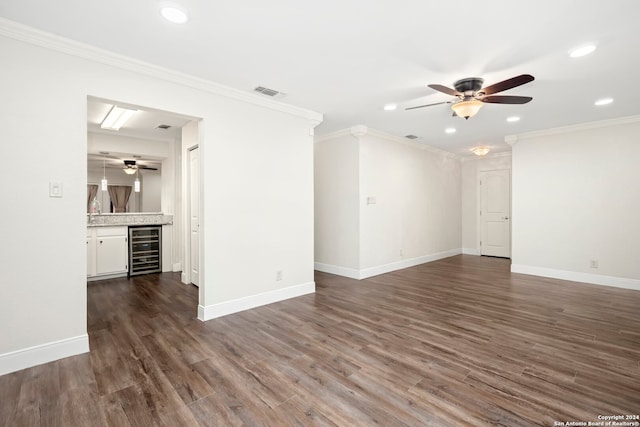 empty room with ceiling fan, beverage cooler, dark hardwood / wood-style floors, and ornamental molding