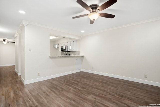 unfurnished living room featuring dark hardwood / wood-style flooring, ceiling fan, and crown molding