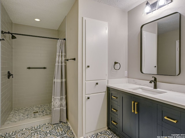 bathroom with tile patterned floors, a shower with curtain, vanity, and a textured ceiling