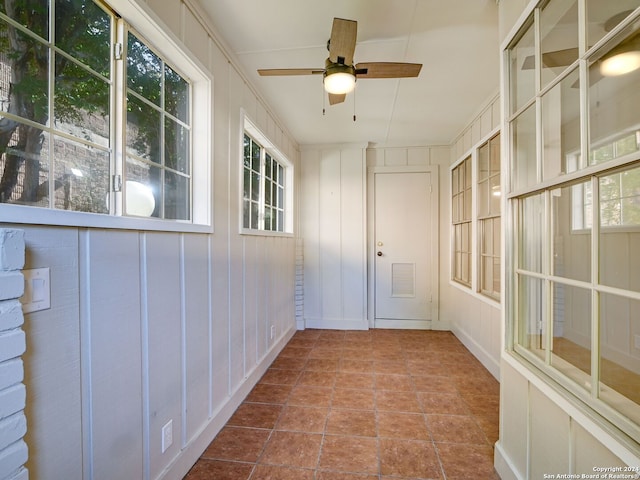 unfurnished sunroom with ceiling fan and plenty of natural light