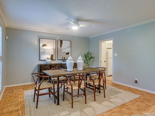 dining area with a textured ceiling, light parquet flooring, ceiling fan, and ornamental molding