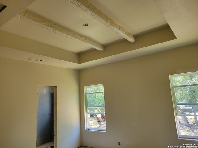 empty room with beamed ceiling