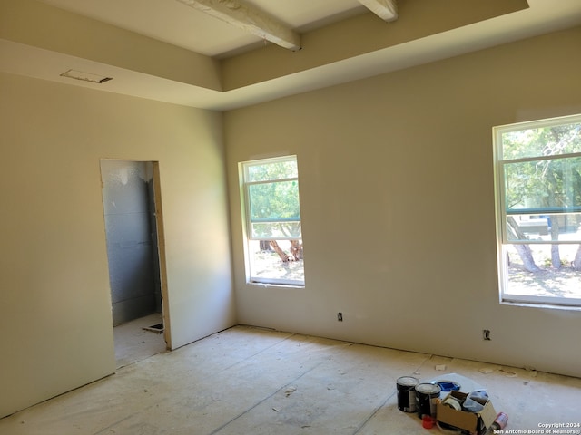 empty room featuring beamed ceiling