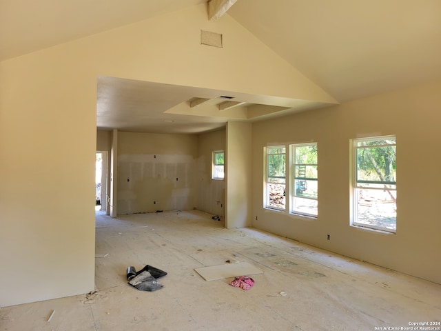 empty room with beamed ceiling and high vaulted ceiling