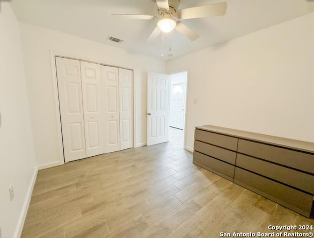 unfurnished bedroom with ceiling fan, a closet, and light hardwood / wood-style floors