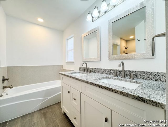 bathroom featuring a washtub, vanity, and hardwood / wood-style flooring