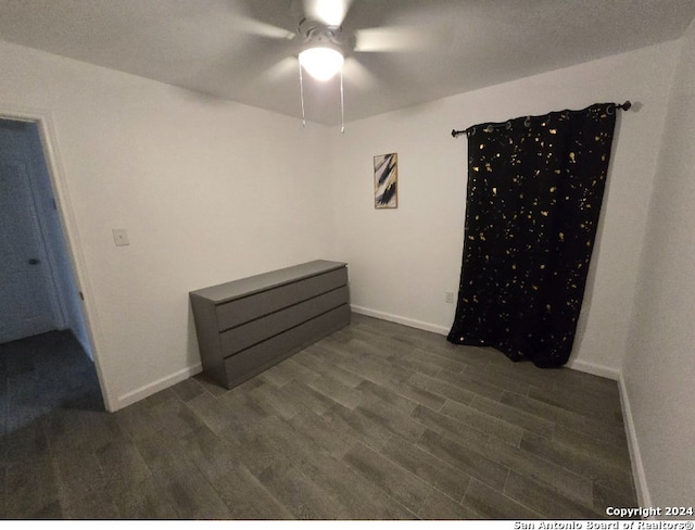 unfurnished bedroom featuring ceiling fan and dark hardwood / wood-style floors