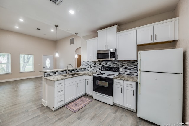 kitchen featuring pendant lighting, sink, white appliances, white cabinetry, and light wood-type flooring