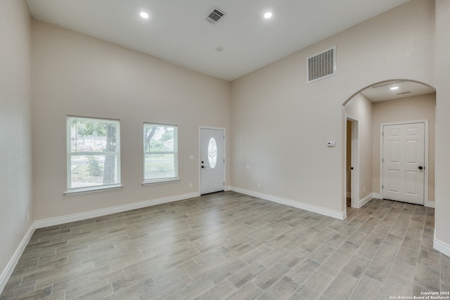 entrance foyer with light hardwood / wood-style floors and a towering ceiling