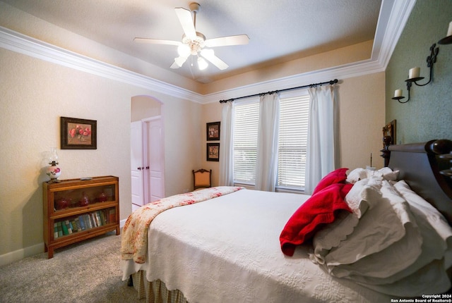 bedroom featuring carpet flooring, crown molding, baseboards, a ceiling fan, and arched walkways