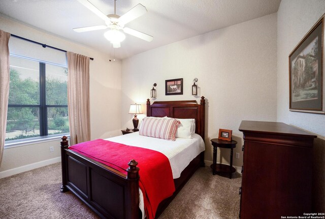 carpeted bedroom with a ceiling fan and baseboards