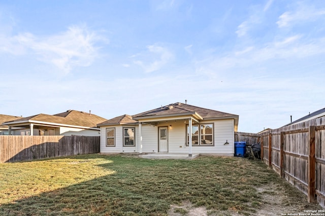 back of house with a lawn and a patio area