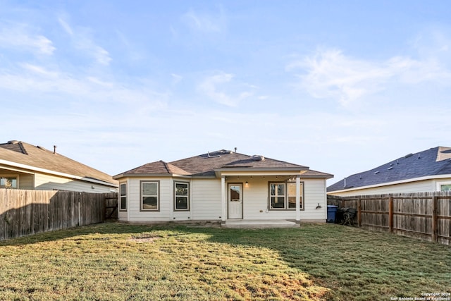 back of house with a yard and a patio