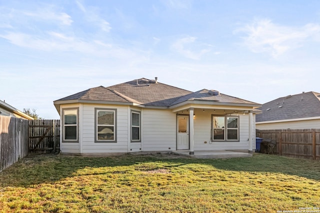 back of property with a patio area and a lawn