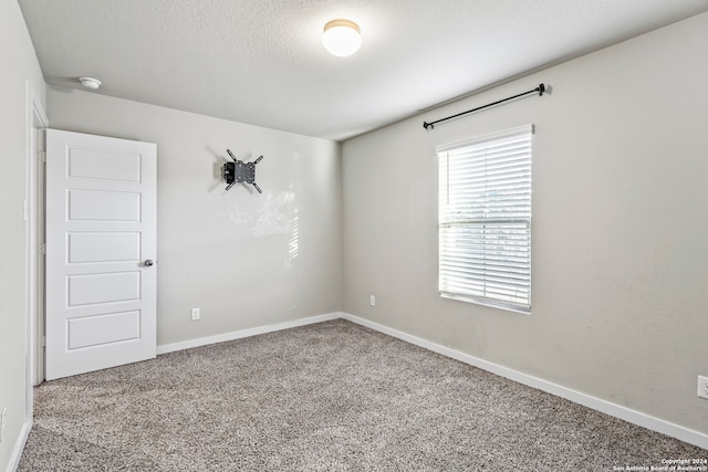 carpeted spare room featuring a textured ceiling