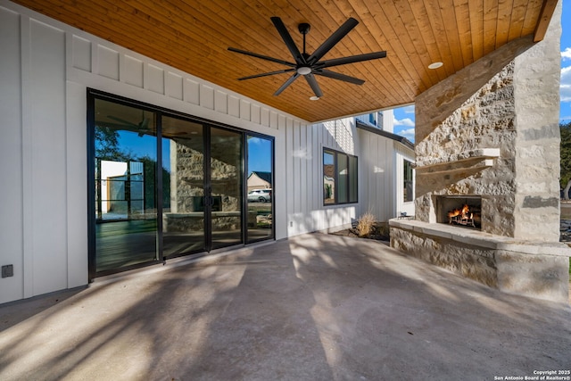 view of patio featuring ceiling fan and an outdoor stone fireplace