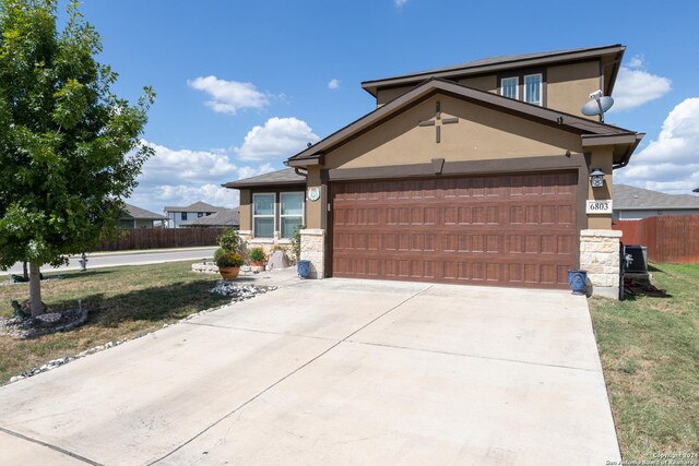 view of front of home featuring stone siding, driveway, fence, an attached garage, and stucco siding