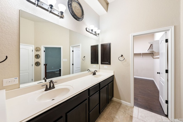 bathroom featuring a towering ceiling, tile patterned floors, and vanity