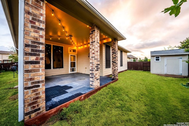 exterior space featuring a storage shed, a patio area, and a lawn