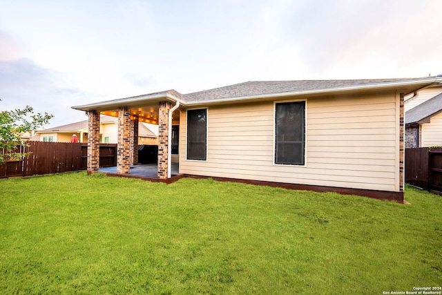 back of property featuring a patio and a lawn