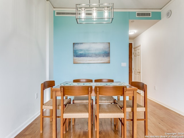 dining space with wood-type flooring and ornamental molding